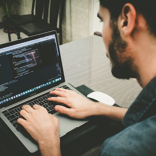 A men using his laptop to write HTML